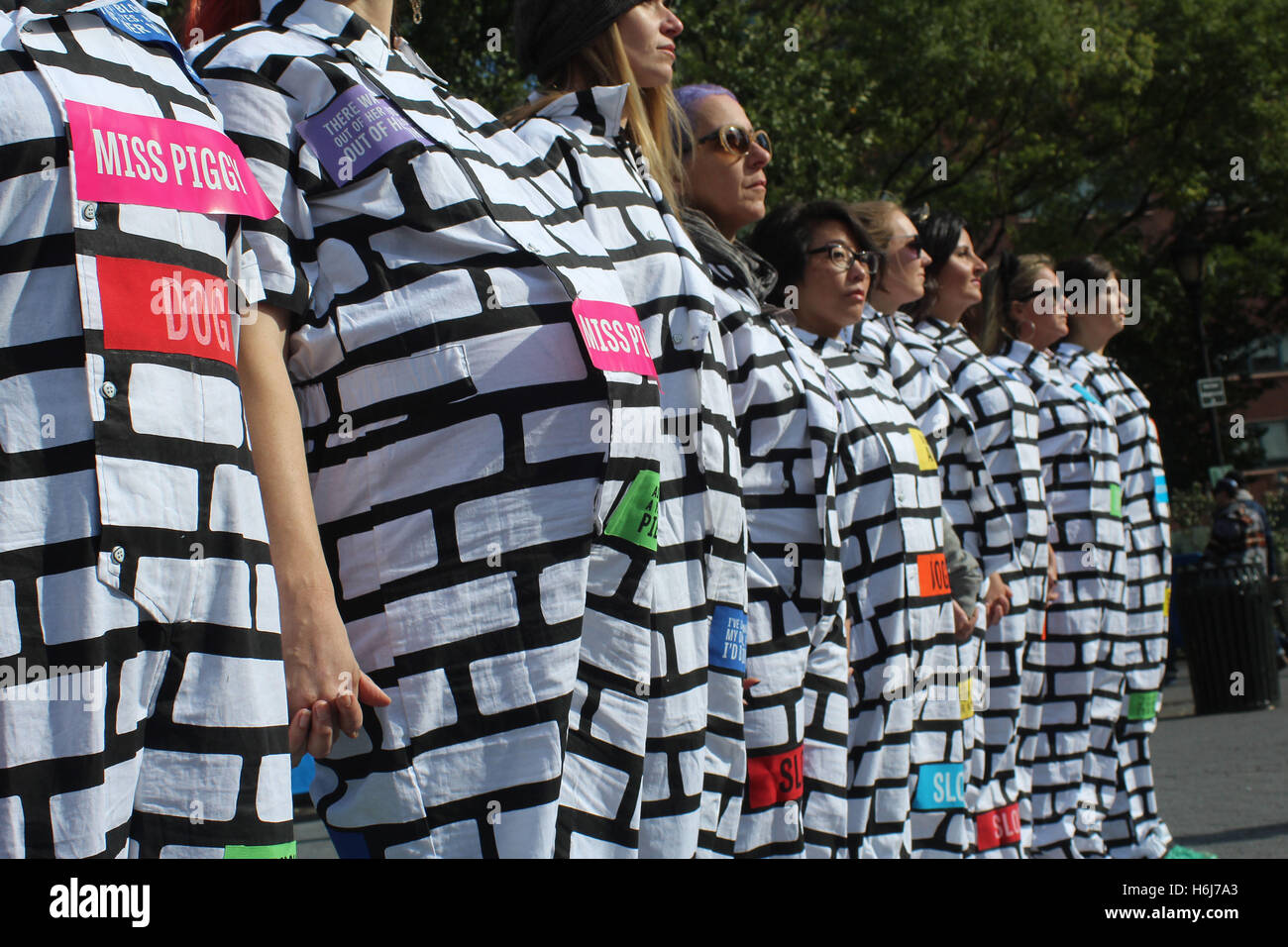 La città di New York New York, US. 29 ott 2016. Azionato da Donald Trump's divisivo lingua, attivisti BrickXBrick.org creato un mattone con motivi a muro fatto di indossare tute le donne che protestavano contro la misoginia e una Trump potrebbe essere la somministrazione. Un aspetto importante del mattone x mattone design sono state colorate applicate le patch per le tute, cuscinetto Trump's sessista commenti ed evidenziando il candidato la lingua come un'ispirazione all'avanguardia della loro opposizione. © 2016 G. Ronald Lopez/ZUMA filo/Alamy Live News Foto Stock