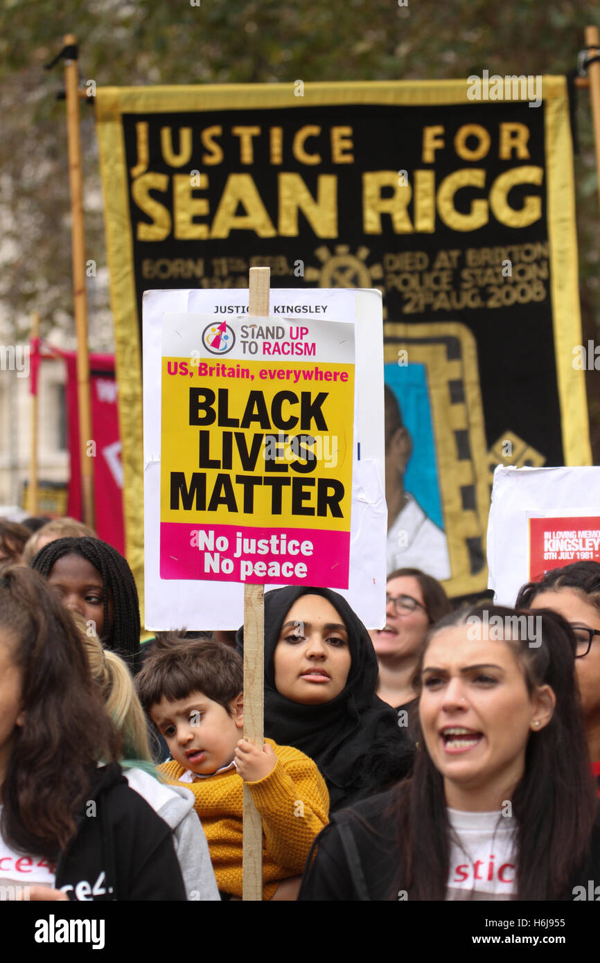 Londra, Regno Unito. 29 ottobre, 2016. Una madre e un bambino tenere una targhetta a Whitehall durante l annuale famiglie unite e amici campagna (UFFC) ricordo processione a Trafalgar Square il 29 ottobre 2016. La silenziosa la precessione è in memeory per coloro che sono morti mentre in custodia di stato. Il UFFC sono state marciando per il passato 18 anni da Trafalgar Square a Downing Street. Aggiornamento, ci sono stati 1577 morte in custodia della polizia dal 1990 con n. di convinzioni. Credito: David Mbiyu/Alamy Live News Foto Stock