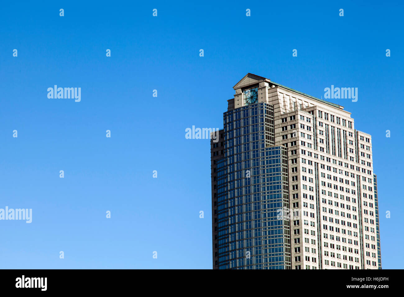 La parte superiore di un edificio alto contro il cielo blu e chiaro su un pomeriggio soleggiato. Foto Stock