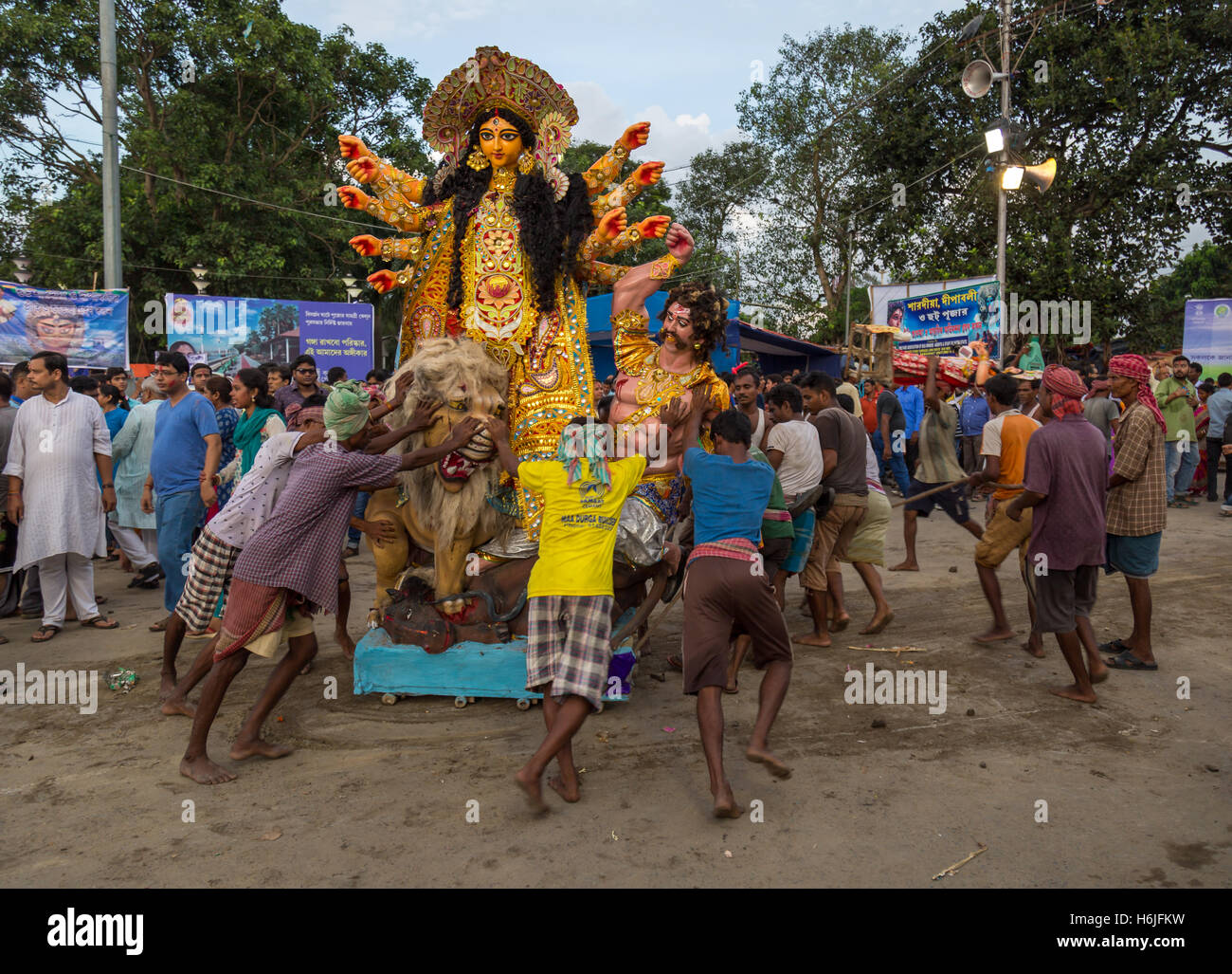 Durga Puja lavoratori spingere Durga idolo al fiume Gange per immersione a Babughat Kolkata, West Bengal, India. Foto Stock