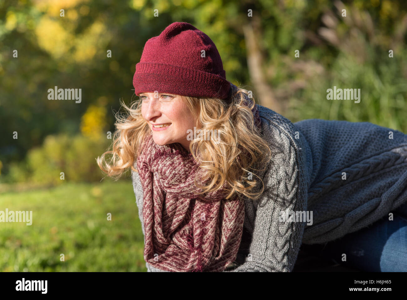 Attraente donna bionda nel parco è lieto circa l'autunno Foto Stock