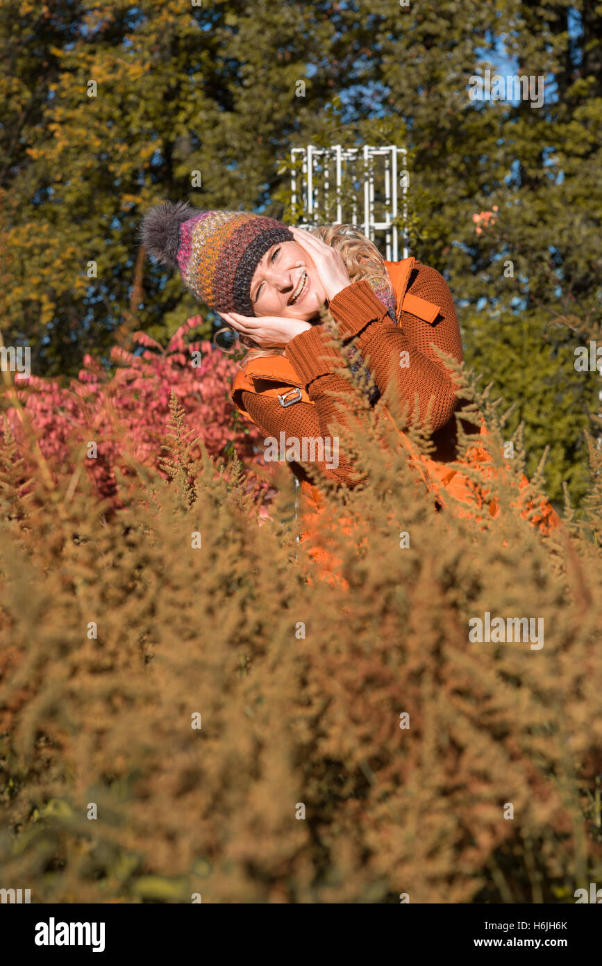 Attraente donna bionda nel parco è impaziente di autunno Foto Stock