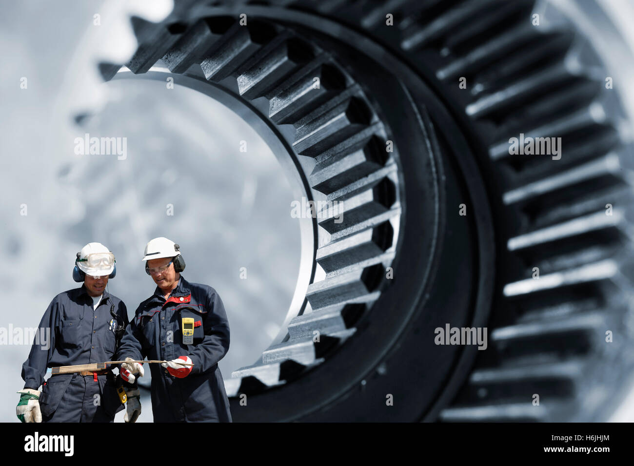 I lavoratori del settore all'interno di ingranaggi gigante assali Foto Stock