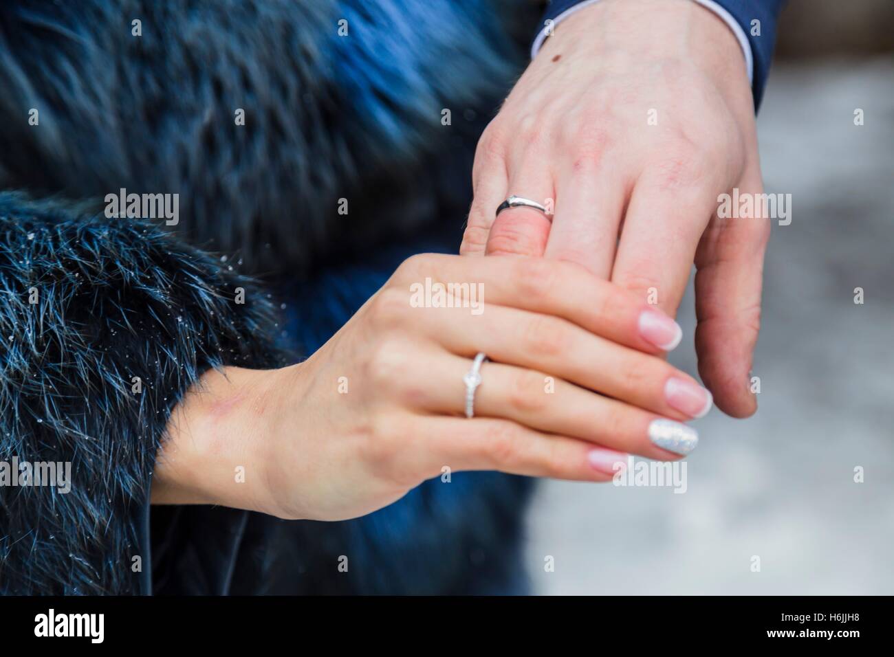 L uomo e la donna mostrano le loro mani con anello di nozze Foto Stock