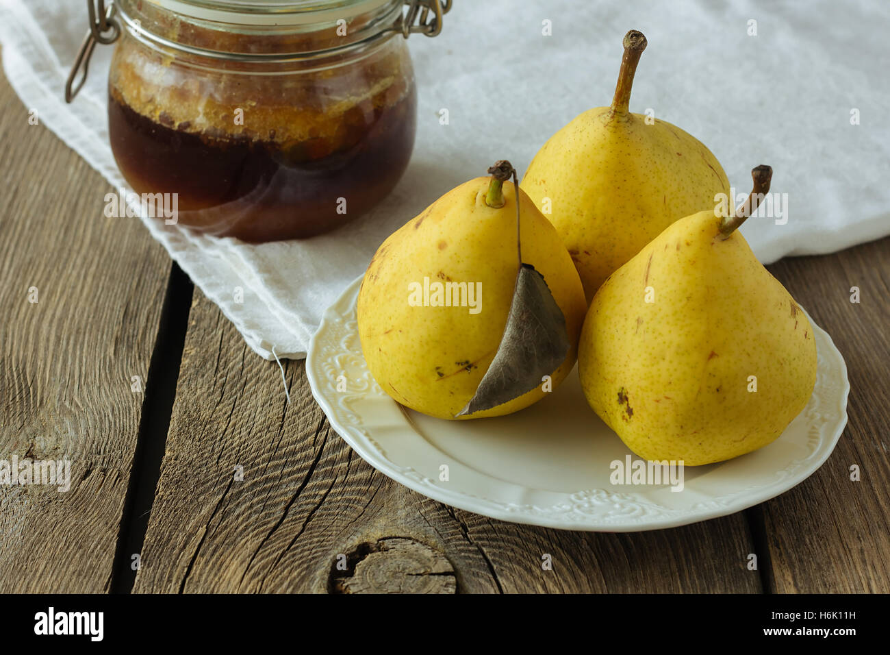 Albero di pere di colore giallo sul piatto bianco e miele messa a fuoco selettiva Foto Stock