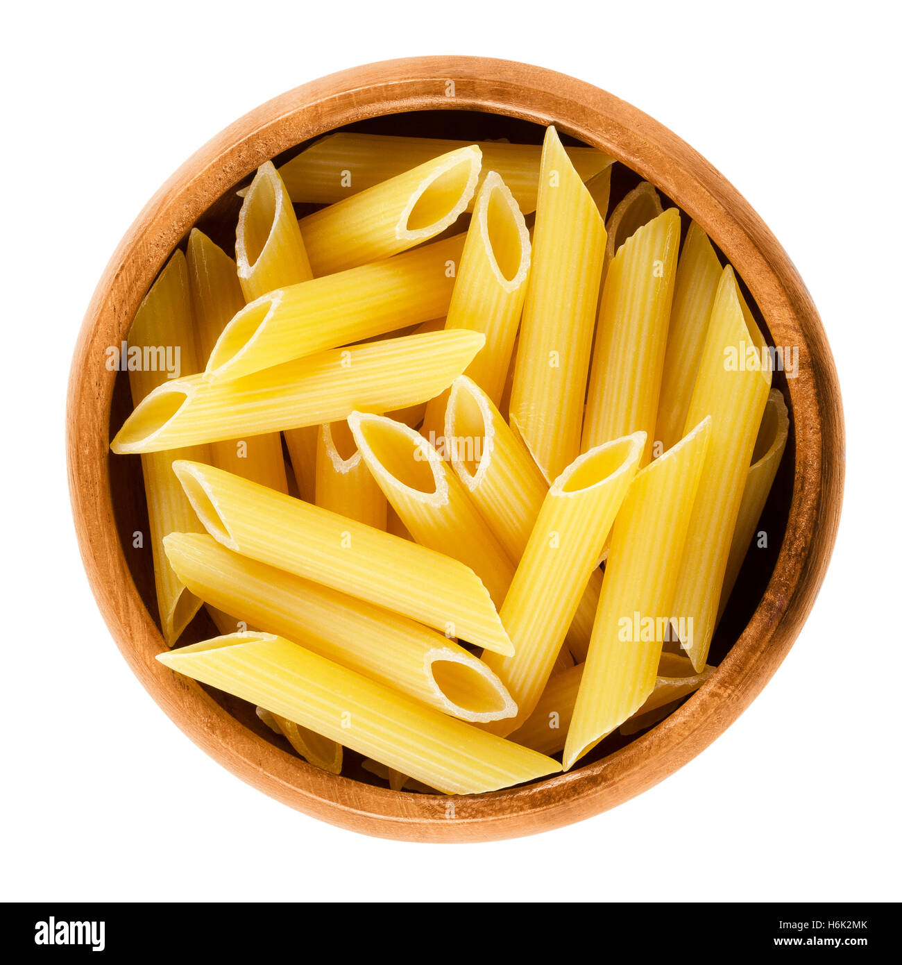 Penne rigate pasta in ciotola di legno. Non cotti essiccato di semola di grano duro tagliatelle. A breve il taglio di media lunghezza tubi con creste. Foto Stock