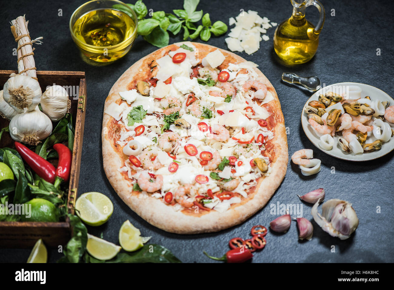 A legna per la pizza fatta a mano con frutti di mare e altri ingredienti Foto Stock