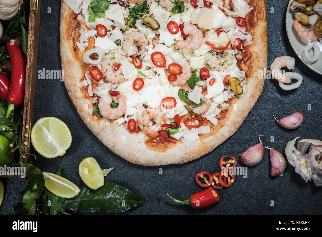 A legna per la pizza fatta a mano con frutti di mare e altri ingredienti Foto Stock