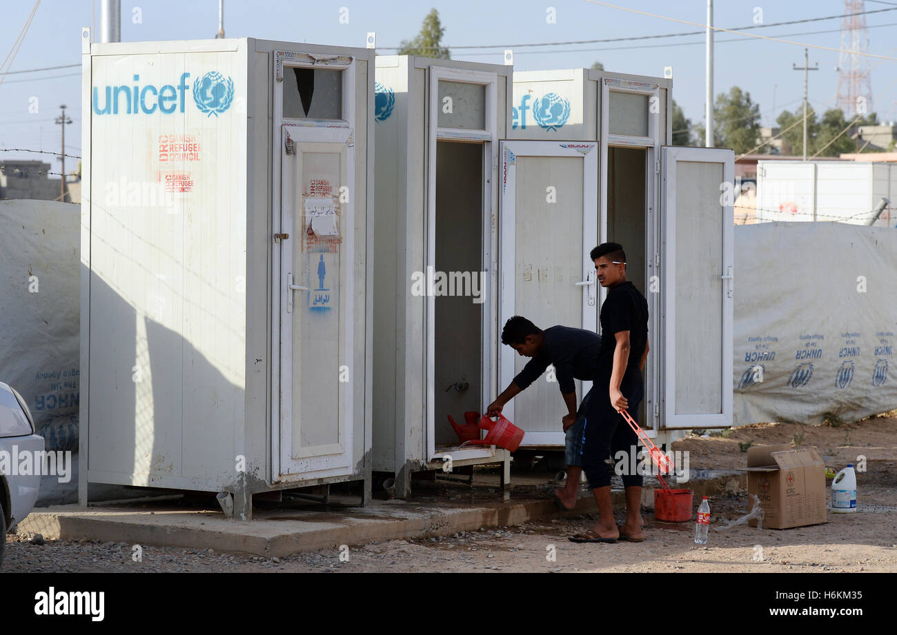 Giovani uomini pulire i servizi igienici, fornito da UNICEF, nel Debaga Refugee Camp tra Mosul e Erbil, Iraq, 18 ottobre 2016. Per i rifugiati delle Nazioni Unite organizzazione di aiuti si aspetta fino a un milione di rifugiati dalla lotta di Mosul. La Germania dovrà essere messa a 34 milioni di euro in aiuti immediati disponibili nella regione. Secondo l UNICEF, più di 500.000 bambini e le loro famiglie sarà un grande pericolo nelle prossime settimane a causa del recuperando della città di Mosul. In previsione di una ondata di profughi, materiali, soprattutto per la fornitura di acqua, vengono portati nella regione. Foto: Jens KALAENE/dpa Foto Stock