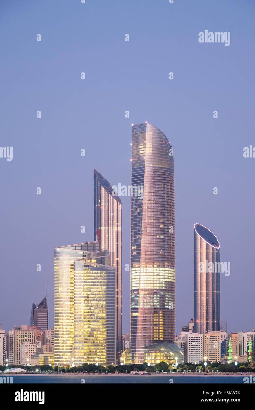 Vista serale di moderni grattacieli sulla Corniche di Abu Dhabi Emirati Arabi Uniti Foto Stock