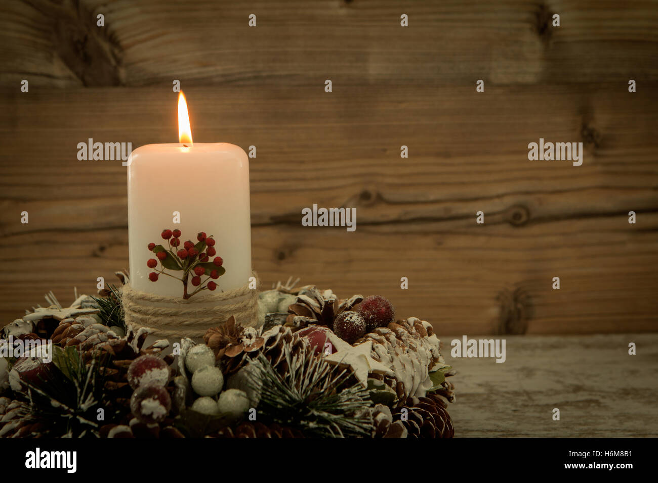 Centrotavola elegante per la tavola del Natale con una candela su una corona di naturale Foto Stock