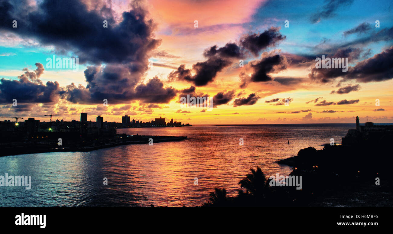 Vista panoramica della baia di Havana e sullo skyline silhouette al tramonto con nuvole drammatico Foto Stock