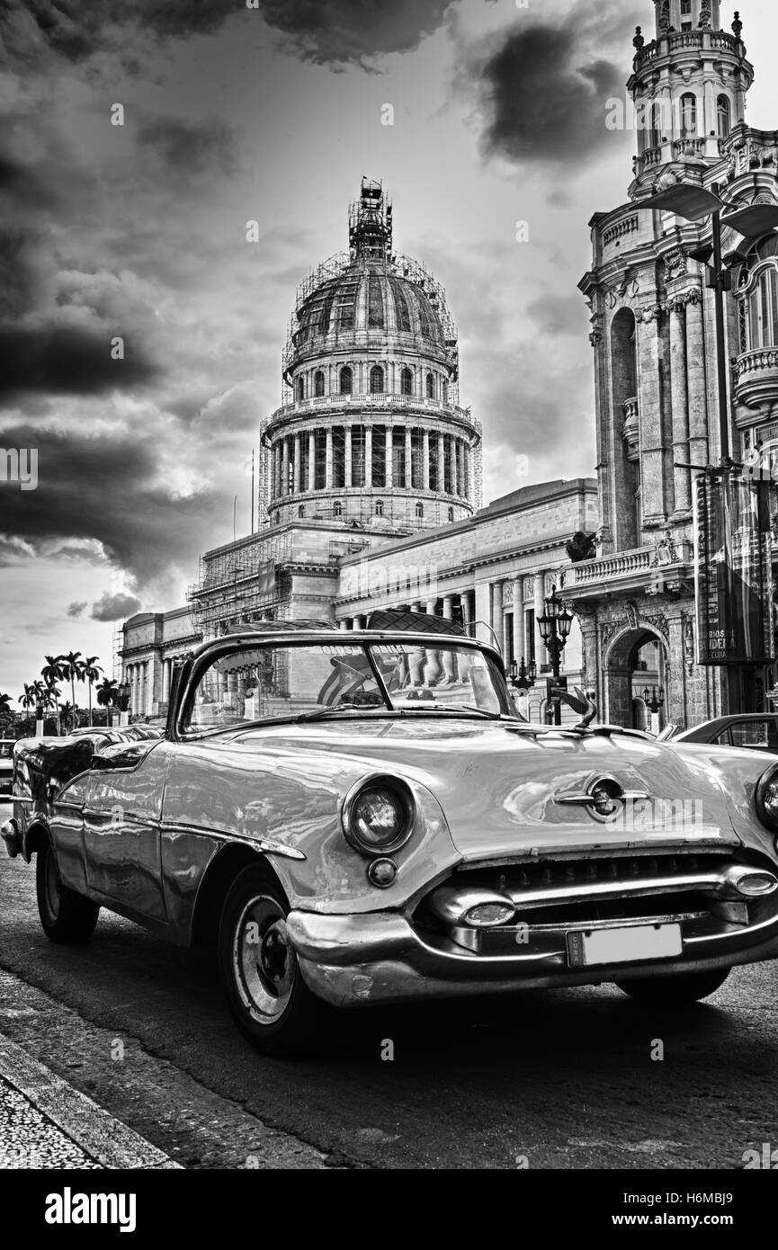 Vintage americano classico auto in una strada di l'Avana Vecchia e il Capitol Building in bianco e nero Foto Stock