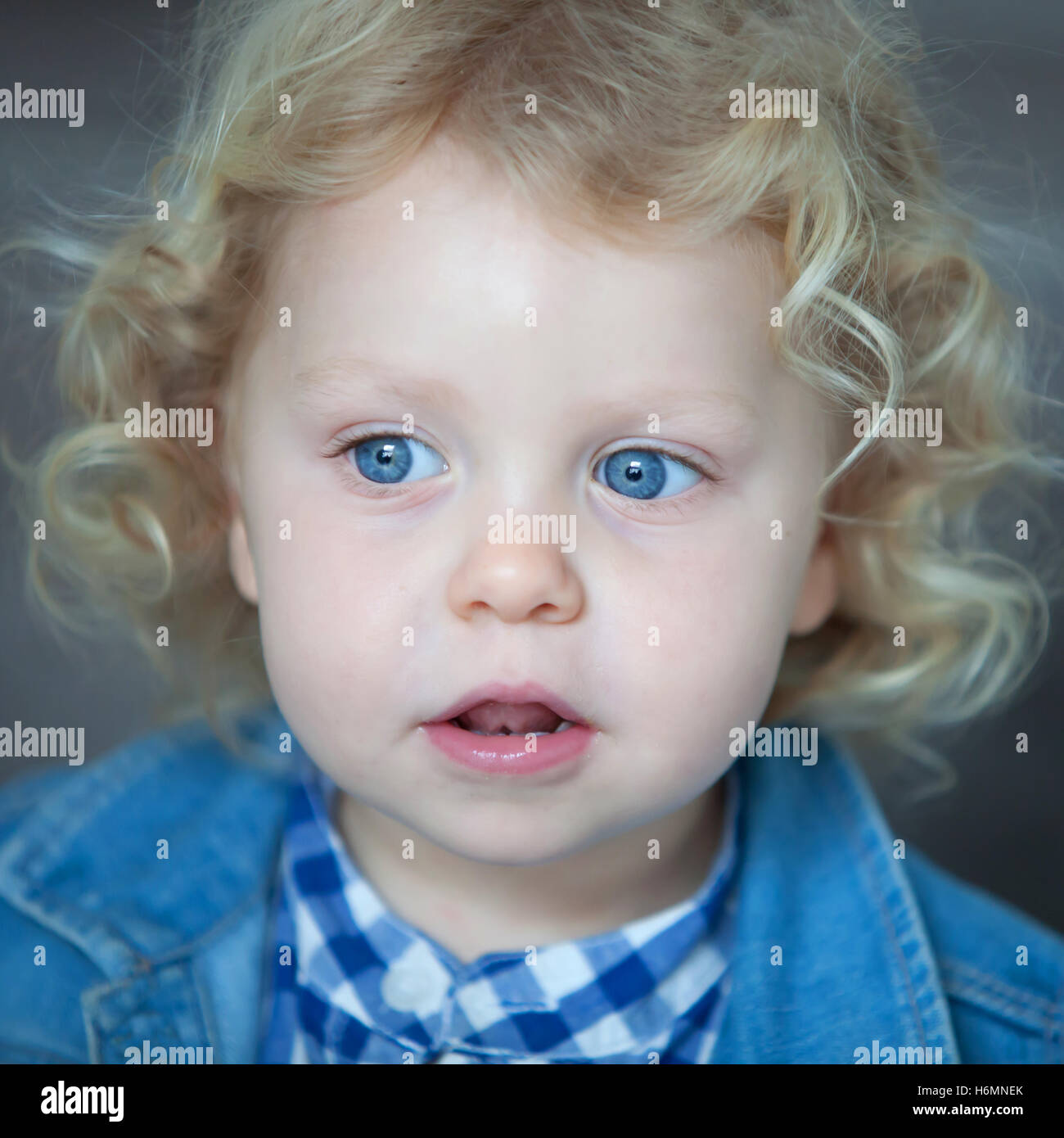Bel bimbo biondo con gli occhi blu e capelli ricci Foto stock - Alamy