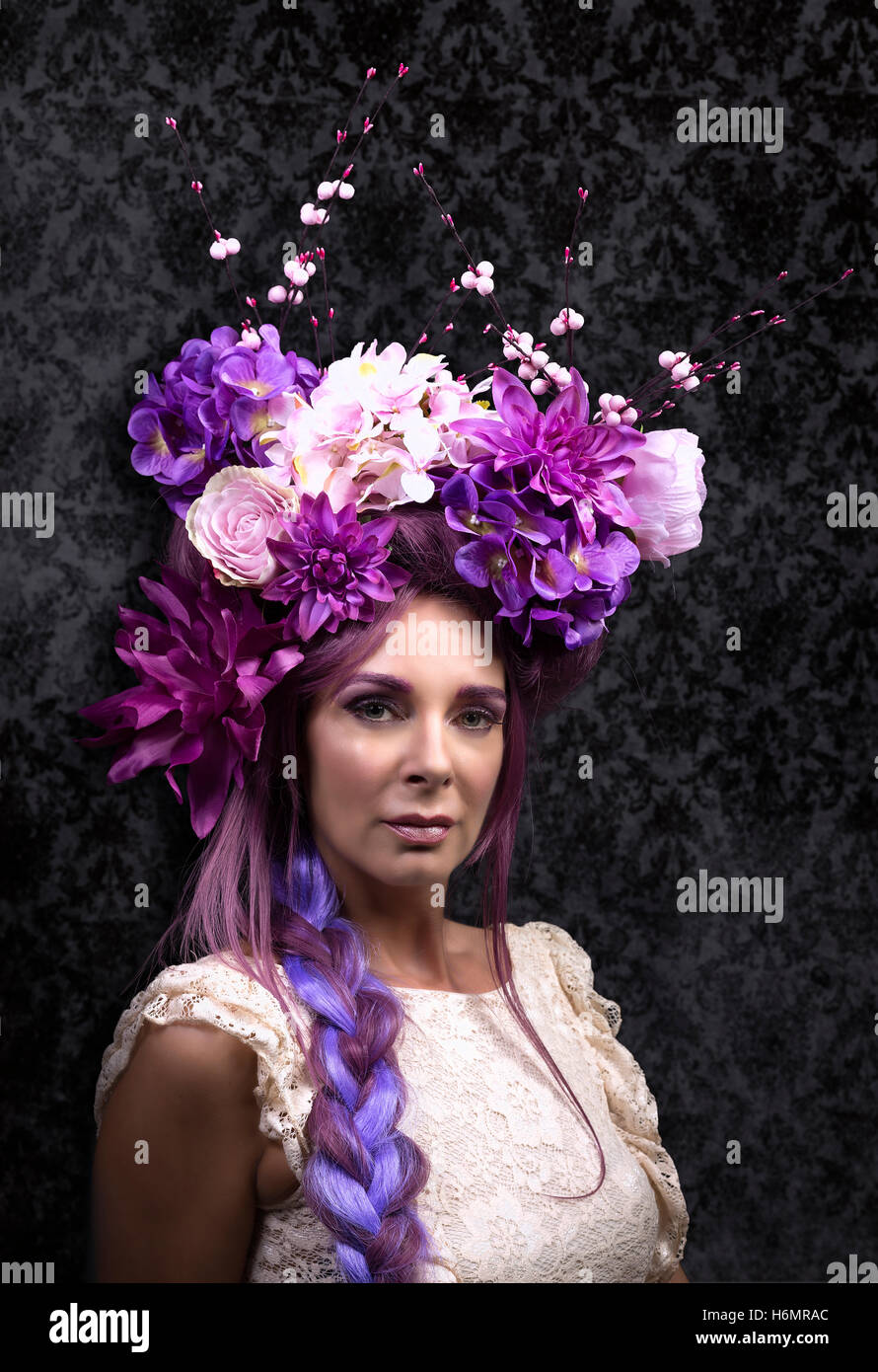 Modello donna con architettura floreale capelli viola pezzo bianco da indossare Abito in pizzo photoshoot contro Damasco nero studio sullo sfondo Foto Stock