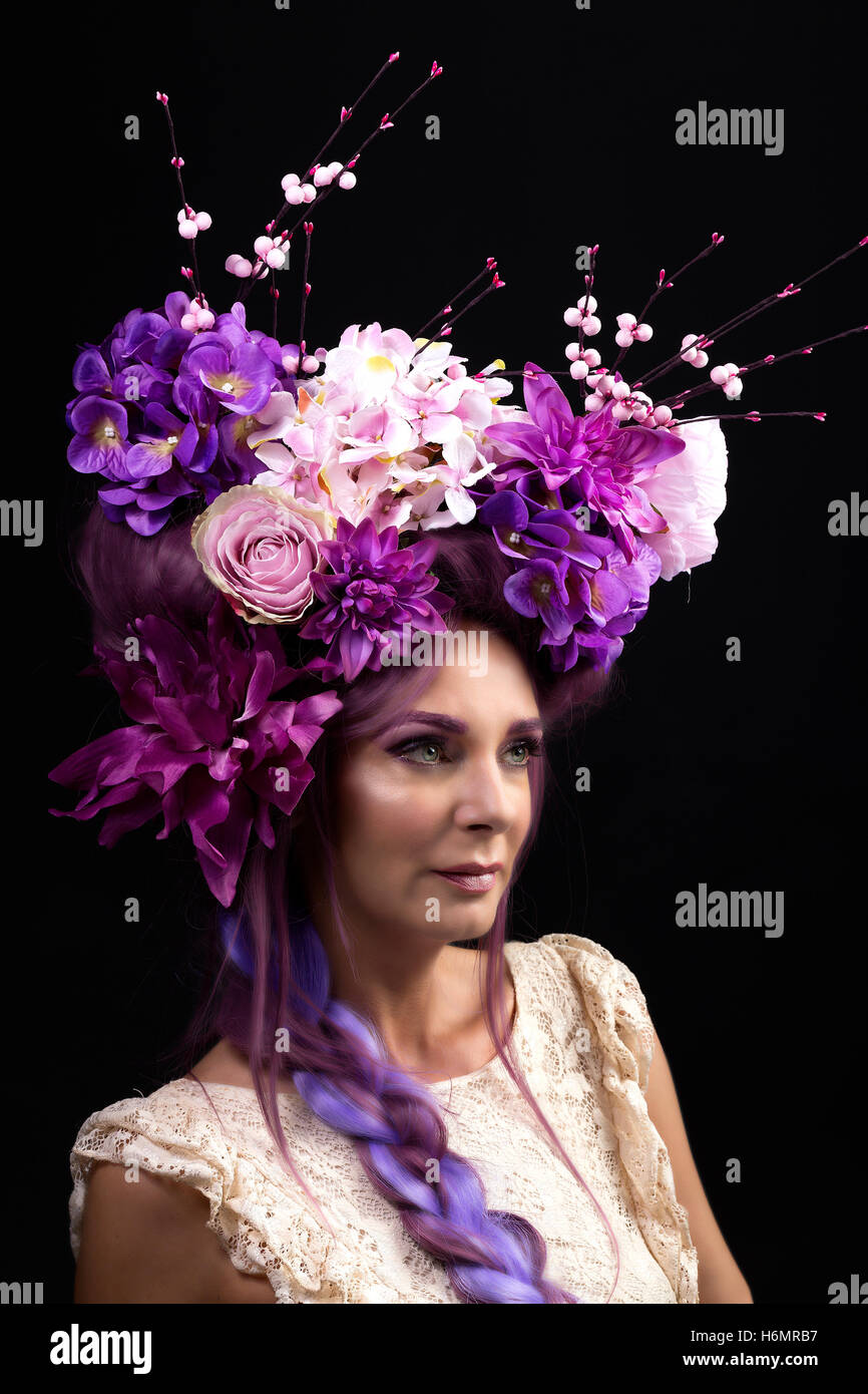 Modello donna con architettura floreale capelli viola pezzo bianco da indossare Abito in pizzo photoshoot contro nero sfondo studio Foto Stock