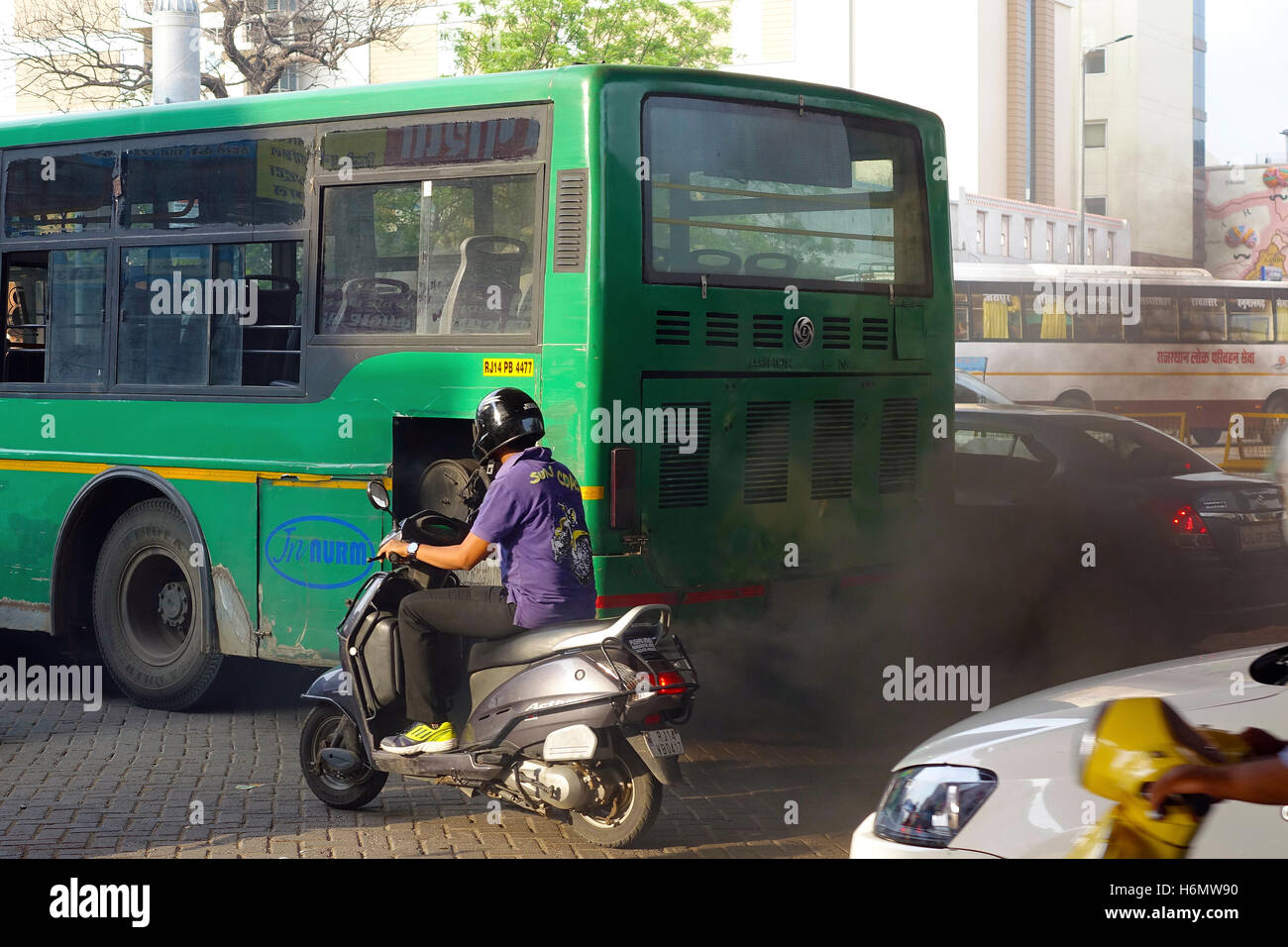 Il rilascio del bus nero scuro e dallo smog strada inquinanti e le strade della città, India Foto Stock