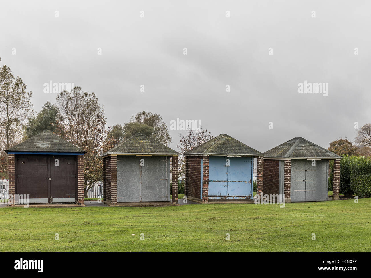 Corro giù cabine sulla spiaggia, sotto il cielo nuvoloso Foto Stock