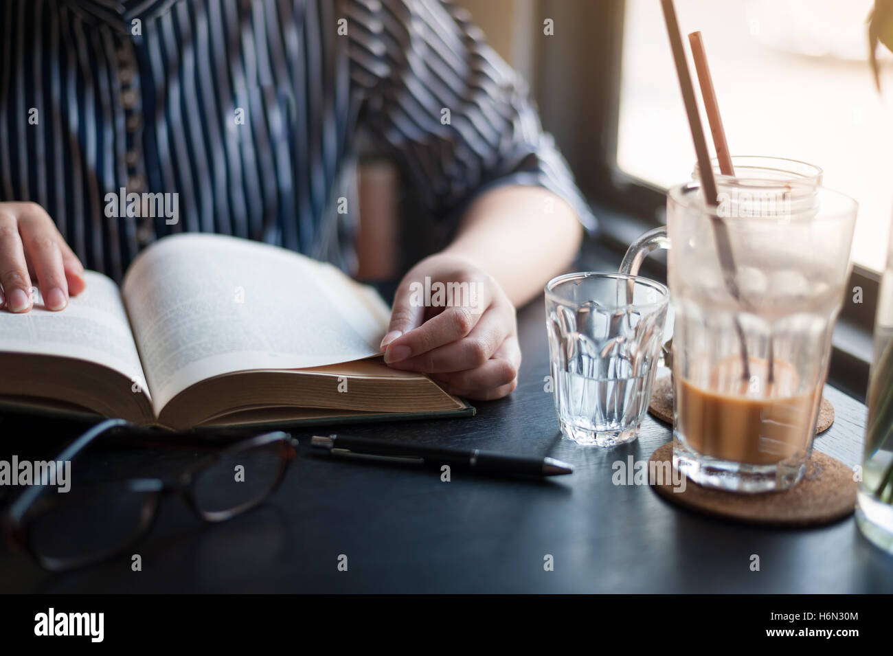 Domenica mattina scena dello stile di vita dei giovani hipster donna libro lettura in cafe con. Fine settimana di attività o hobby concept Foto Stock