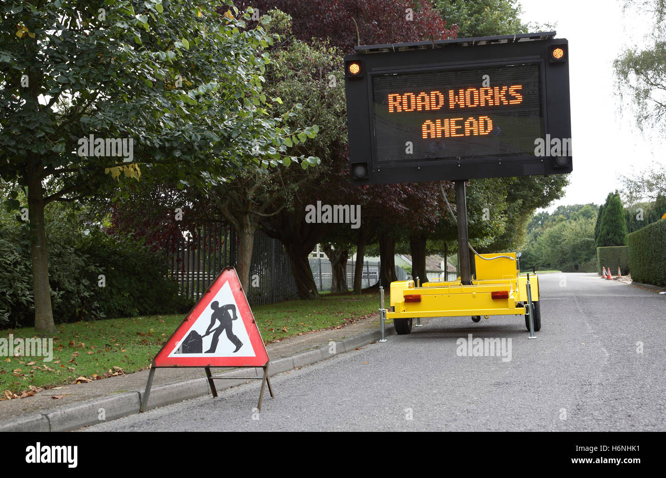 Una banchina mobile, alimentati a energia solare dot-matrix cartello stradale mostra il messaggio: lavori stradali in anticipo Foto Stock