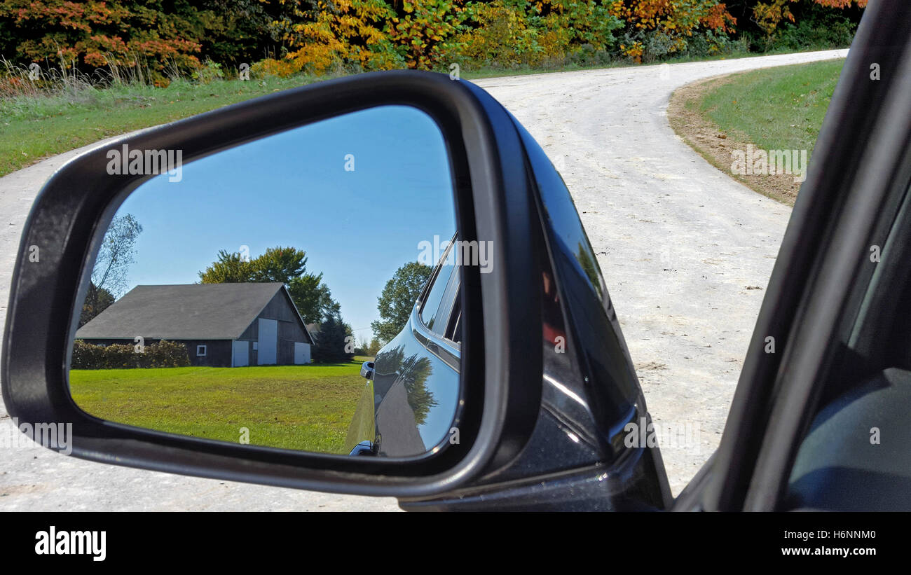 Specchietto retrovisore sul veicolo con fienile rurale la riflessione Foto Stock