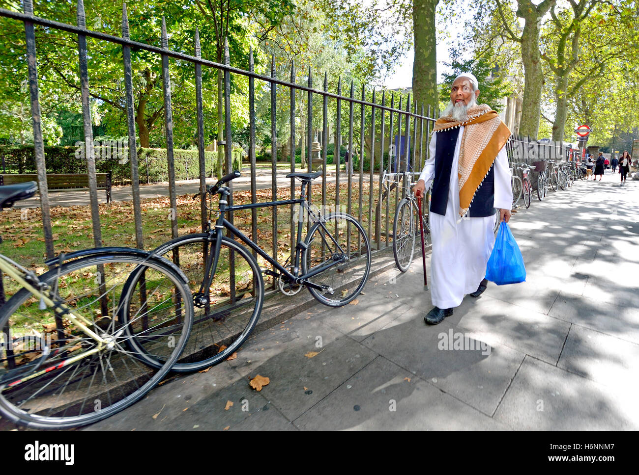 Londra, Inghilterra, Regno Unito. Anziani uomo musulmano a piedi nella Whitechapel Foto Stock