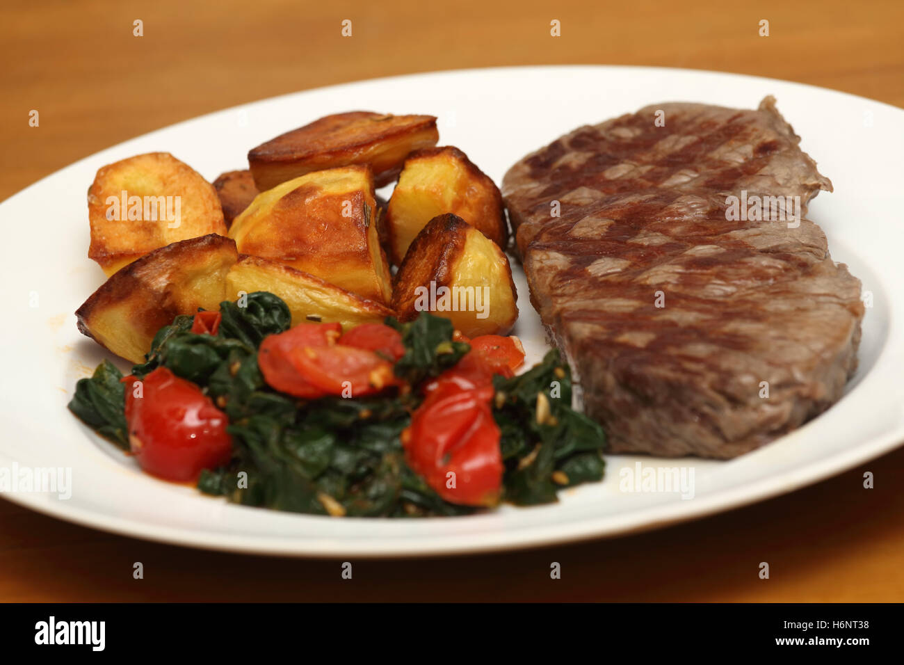 Scamone bistecca con patate fritte e spinaci Foto Stock