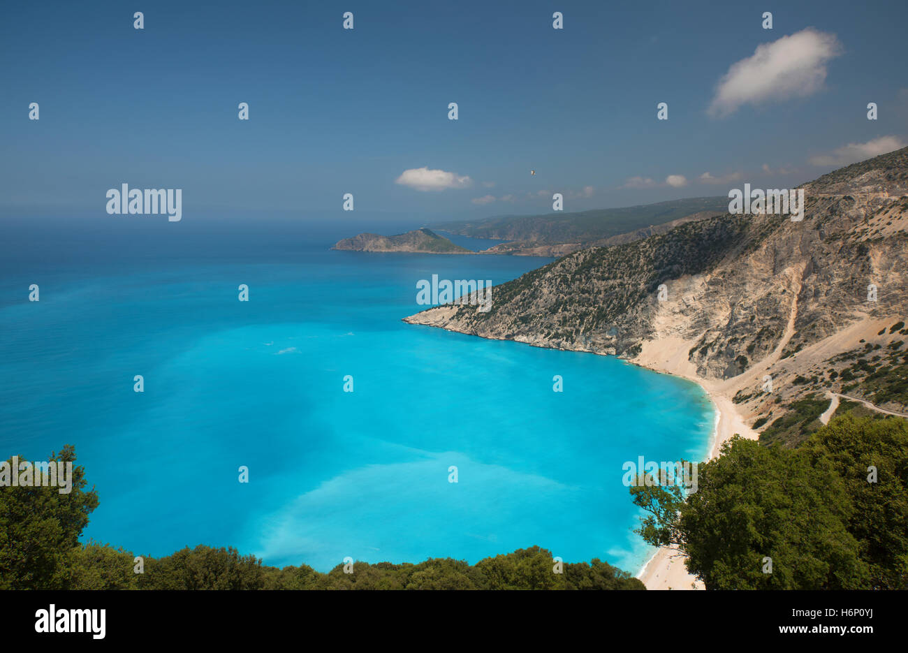 Vista della spiaggia di Myrtos, sull'isola greca di Cefalonia, con il villaggio di Assos a distanza Foto Stock