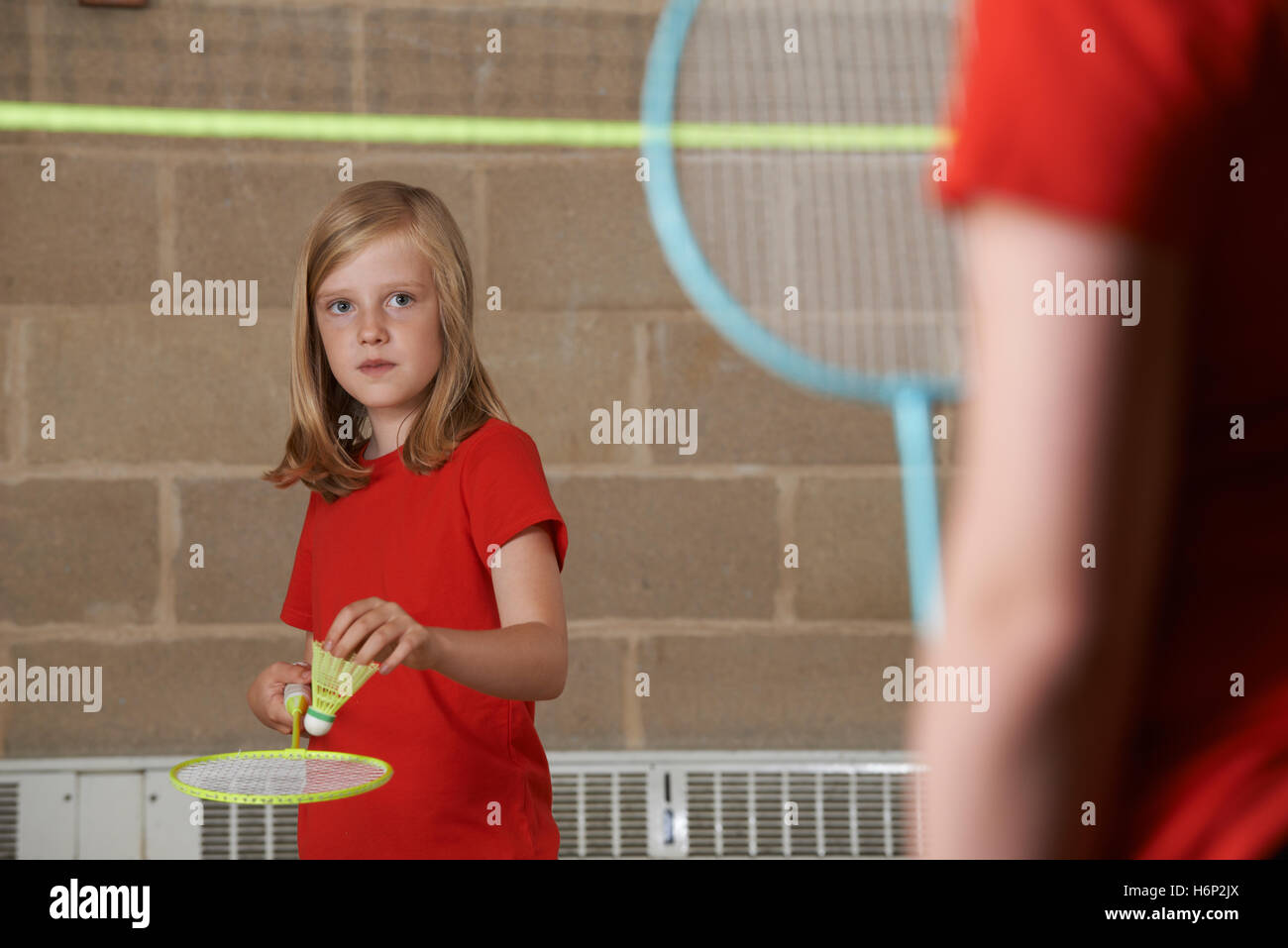 Due ragazze la riproduzione di badminton nella palestra della scuola Foto Stock