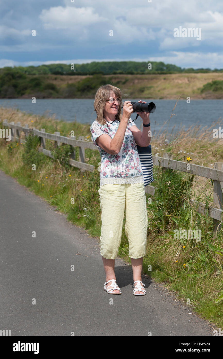 Femmina adulta fotografo tenendo fotografia sulla fotocamera digitale. Foto Stock