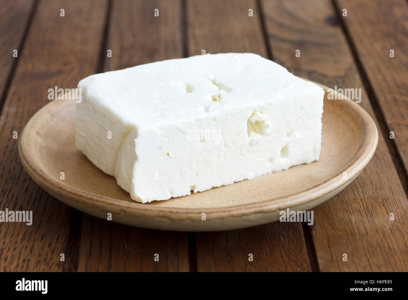 Greco di formaggio feta il blocco sulla piastra di rustico e tabella. Foto Stock