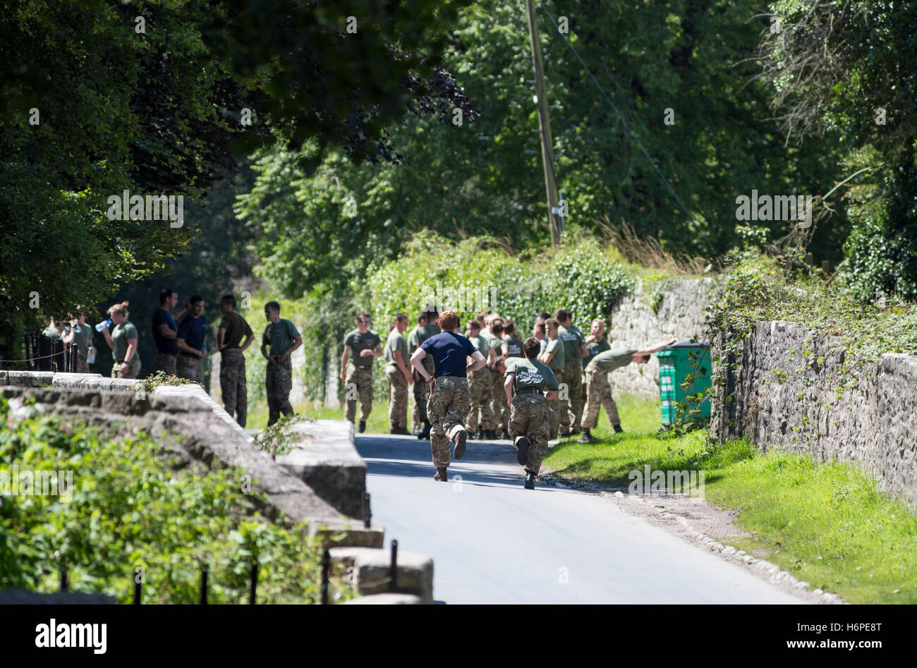 I giovani che mostra il lavoro di squadra e assistenza in materia militare addestramento fisico esercizio Foto Stock