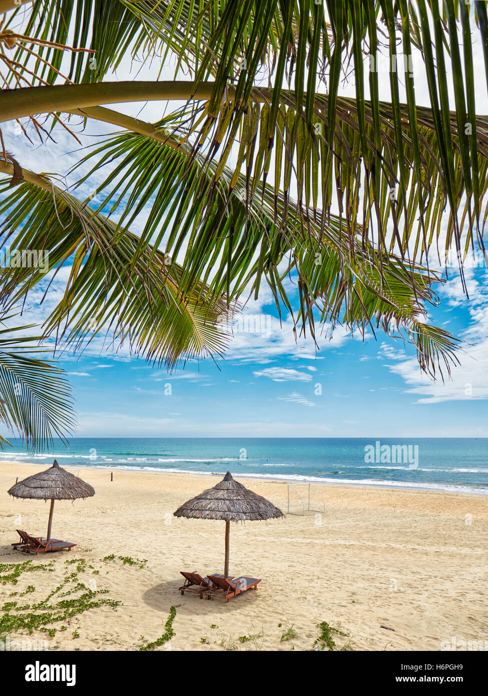 Sedie a sdraio sotto gli ombrelloni di paglia su Lang Co Beach. Thua Thien Huê Provincia, Vietnam. Foto Stock