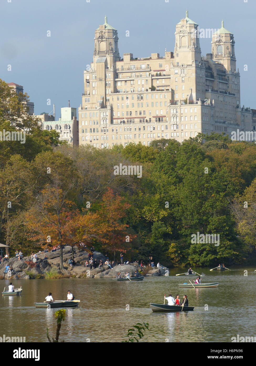 Barche a remi con coppie di Central Park, NY con il Beresford torre residenziale progettata dall architetto Emery Roth, costruito nel 1929 Foto Stock