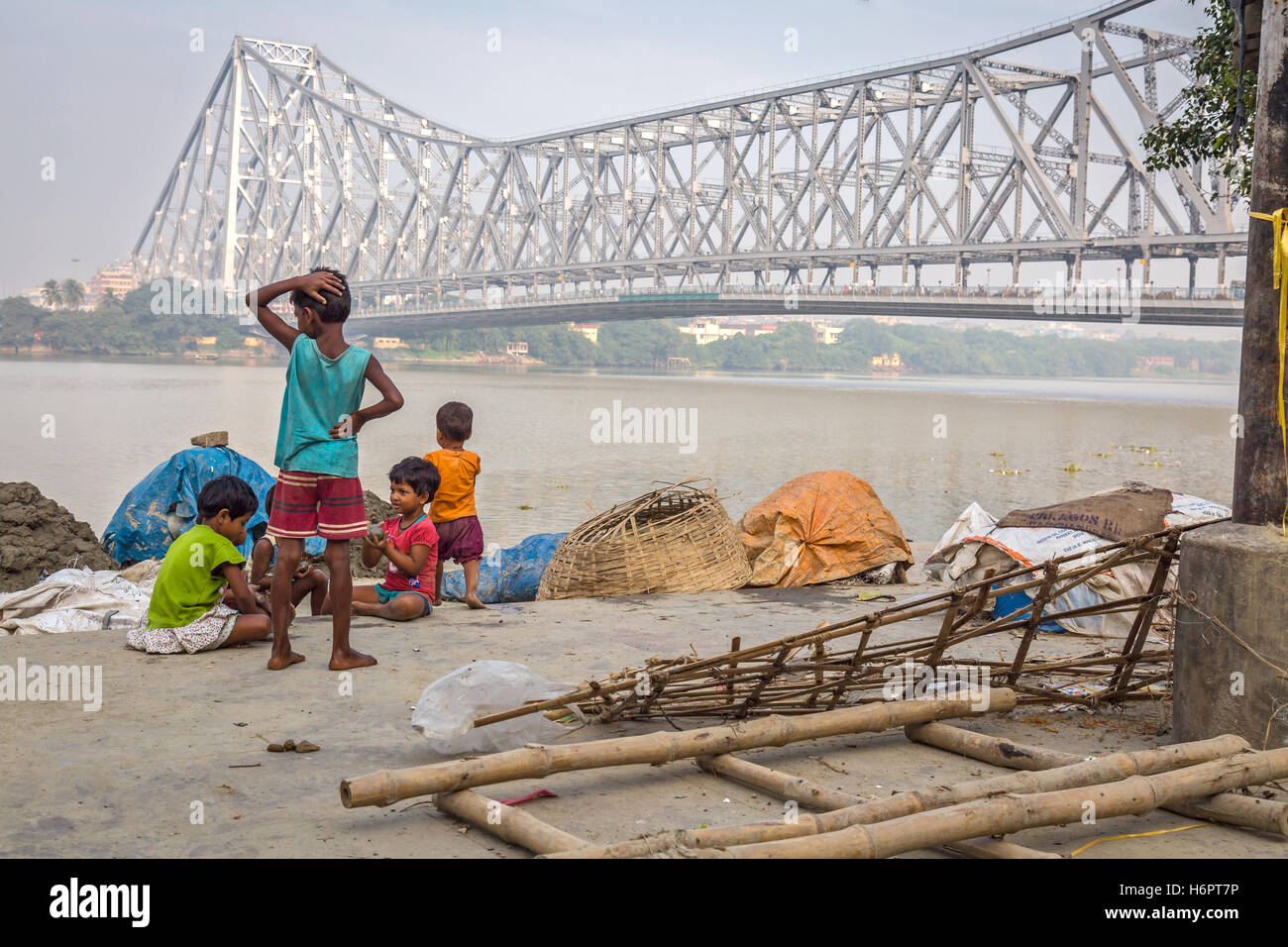 Bambini di strada giocare presso la banca del fiume Gange a Mallick ghat vicino a quella di Howrah bridge, Calcutta, India. Foto Stock