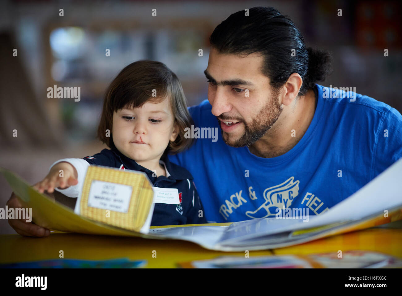 Papà la lettura al figlio prenota daddy ambiente scolastico condivisione maschio divertimento istruzione lezioni agli studenti di studiare un ulteriore studio studio Foto Stock