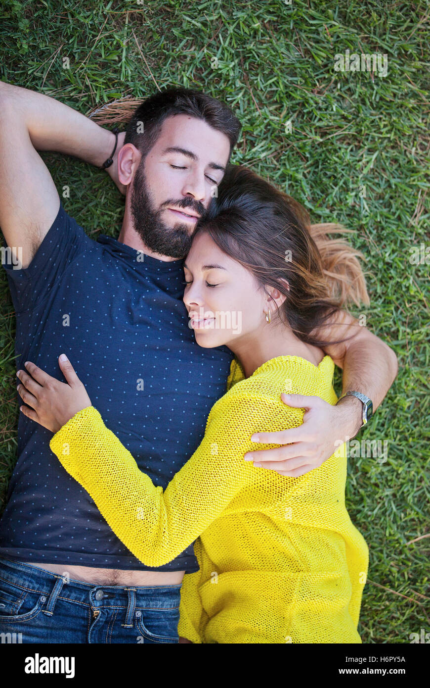 Coppia felice in amore posa su erba in estate Foto Stock