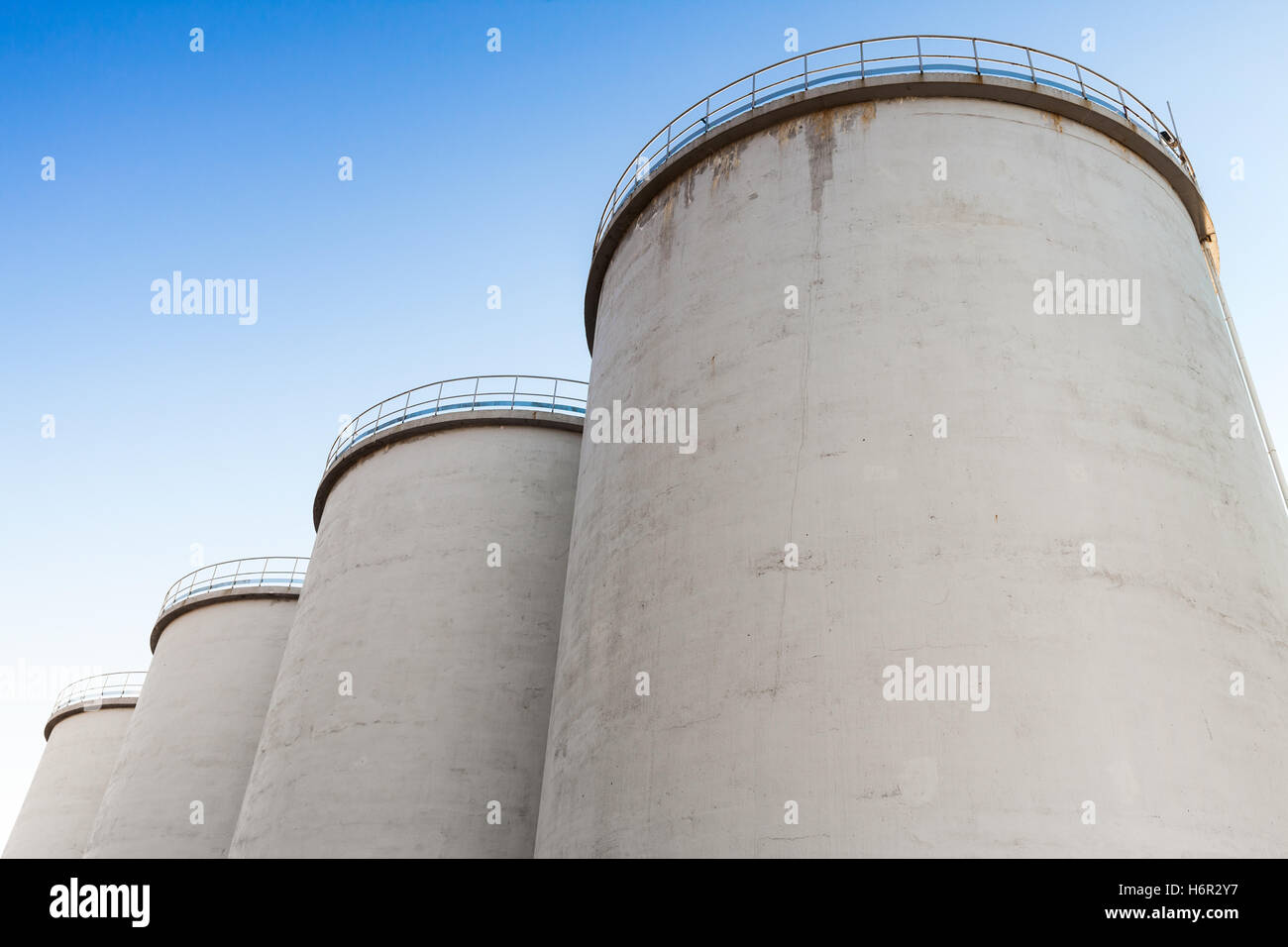 Serbatoi in cemento per lo stoccaggio di materiali sfusi sotto il cielo blu Foto Stock
