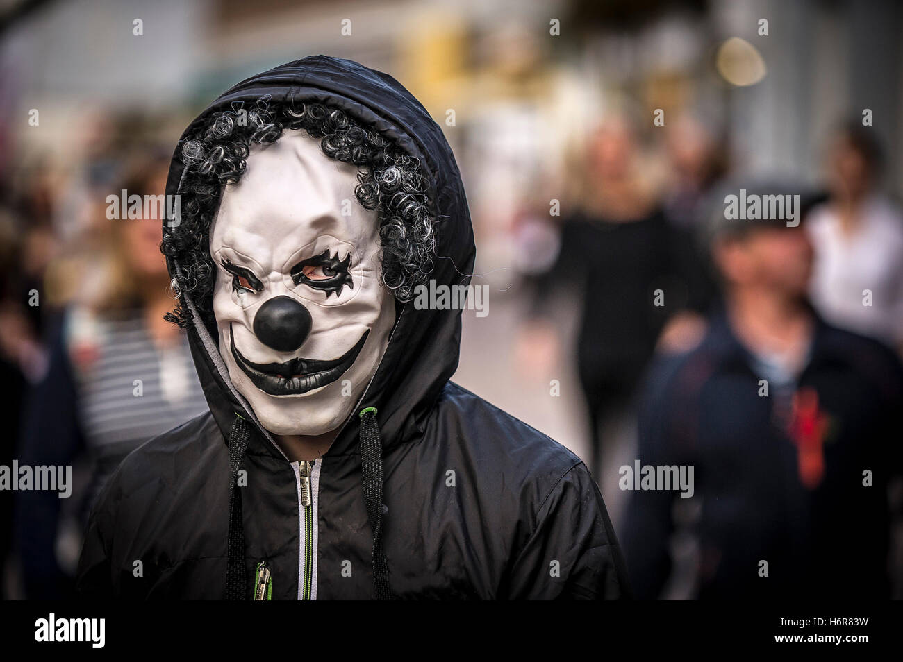Un adolescente che indossa una maschera da clown durante le celebrazioni di Halloween. Foto Stock