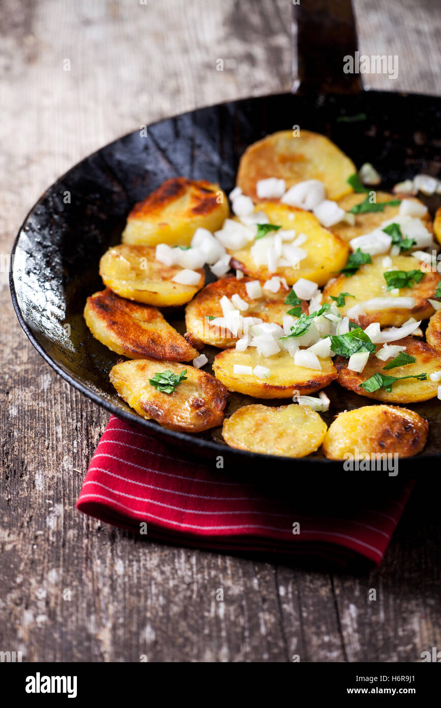 Patate fritte in una padella di ferro Foto Stock