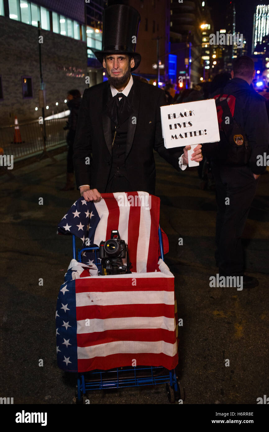 New York, NY - 31 ottobre 2016. Un uomo in un tubo da stufa hat e costume come Abraham Lincoln tiene un cartello che recita "Back vive materia." Il segno anche capovolto per leggere "repubblicani per Hillary.' Credit: Ed Lefkowicz/Alamy Live News Foto Stock