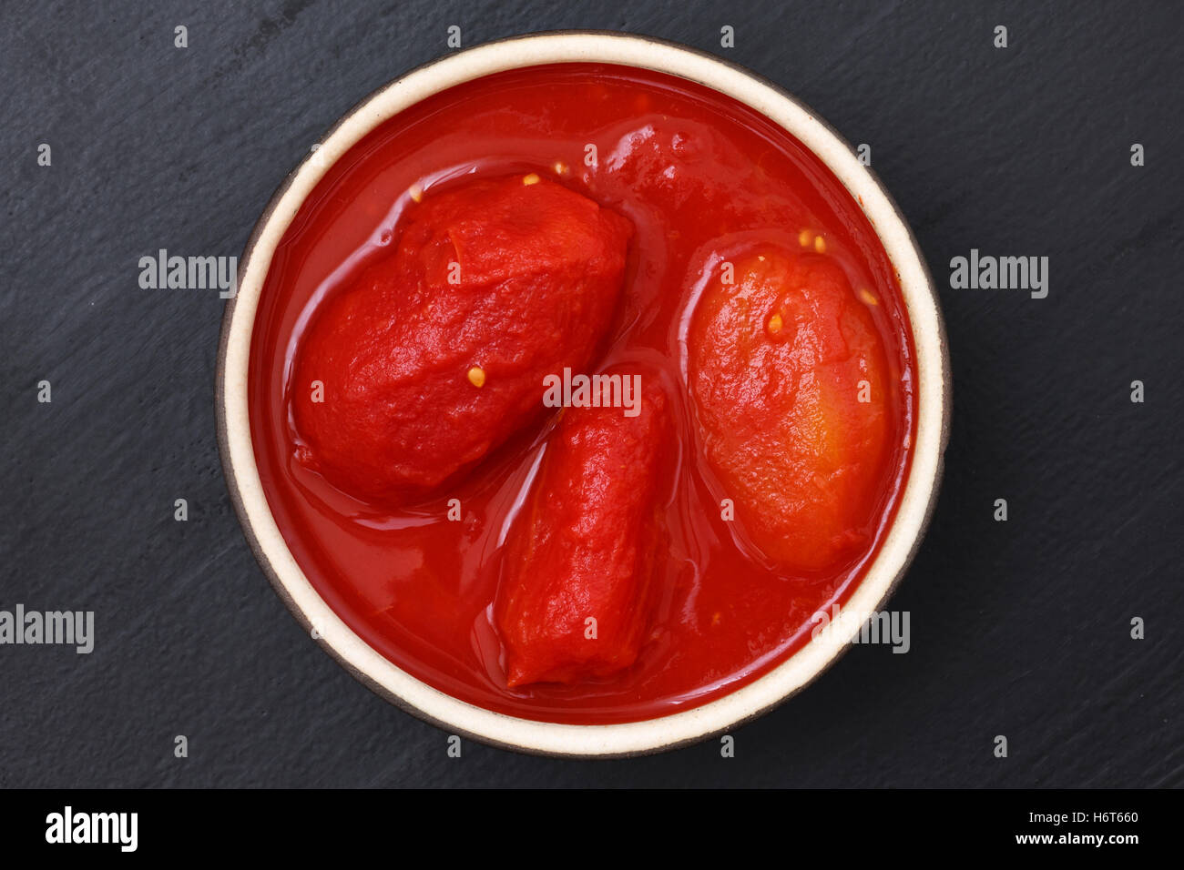 Tutto conserve di pomodori nel piatto dal di sopra sul legno nero. Foto Stock