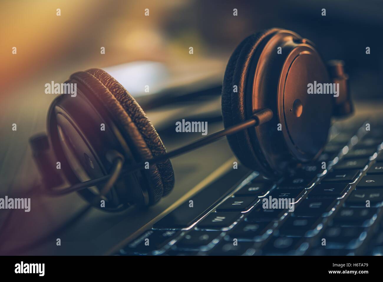 Musica digitale online e le cuffie del computer portatile. Cuffie professionali sulla tastiera del computer. Foto Stock