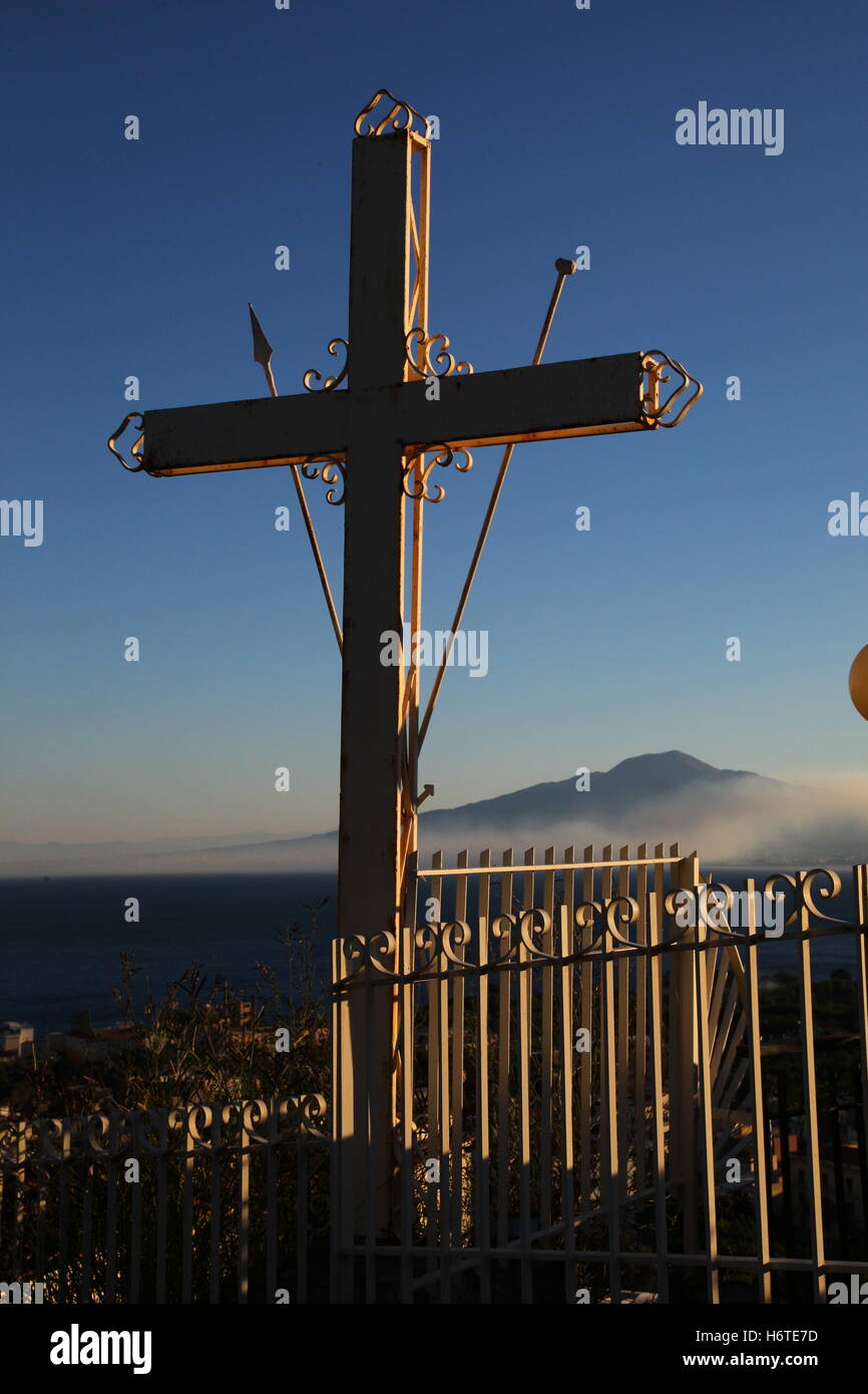 Segno della Croce sul Monte Vesuvio visto in background è avvolta nella nebbia di ringhiere metalliche circostanti la protezione incrociata il male. Foto Stock