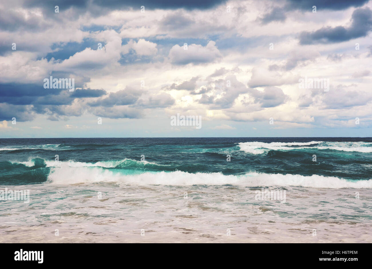 Retrò tonica drammatico spiaggia tempestosa scena. Nuvole grigie e mare mosso su una deserta spiaggia Garie, Royal National Park, NSW Foto Stock