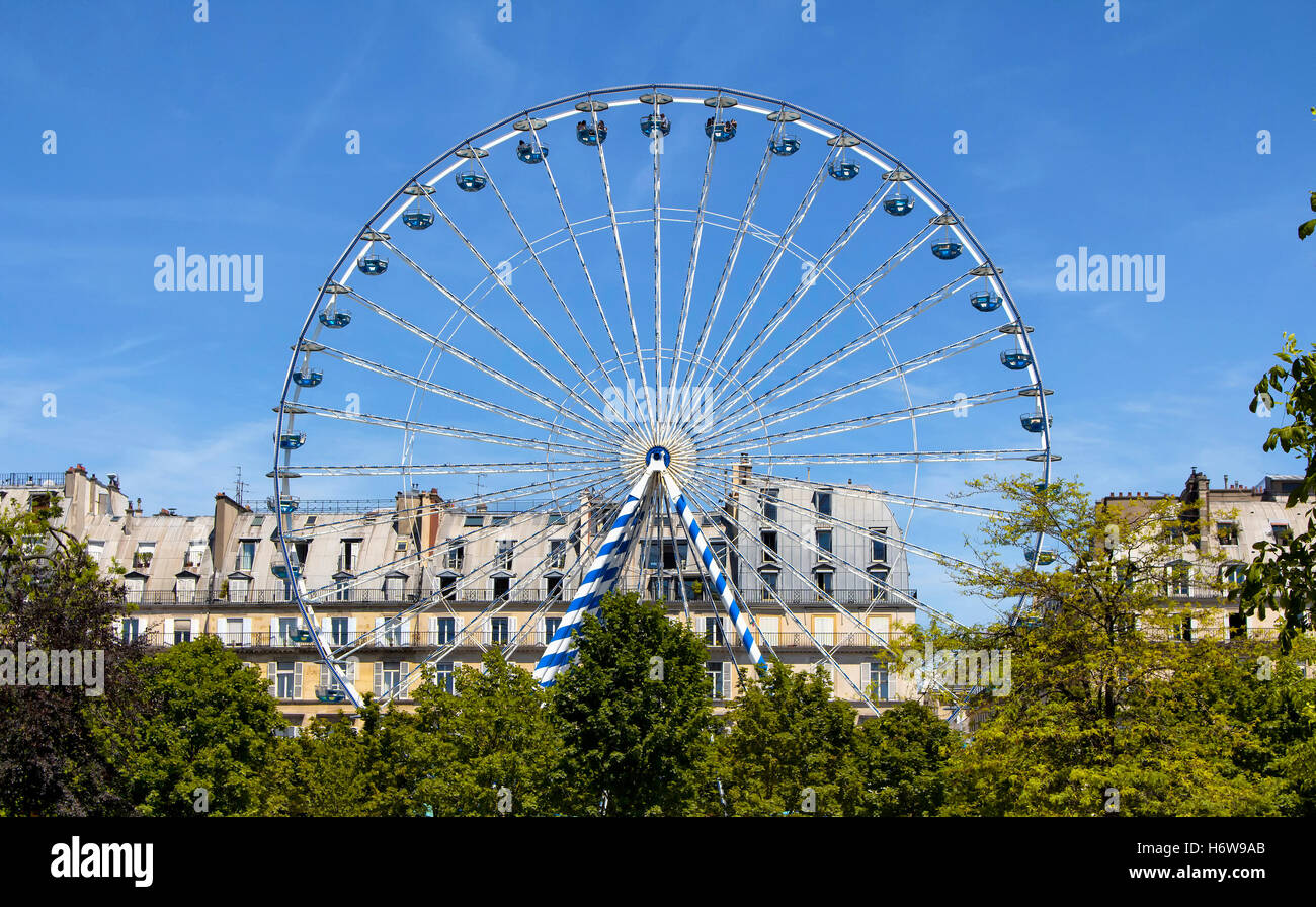 Vista della ruota panoramica Ferris, alberi ed edifici al Jardin des Tuileries di Parigi. Foto Stock