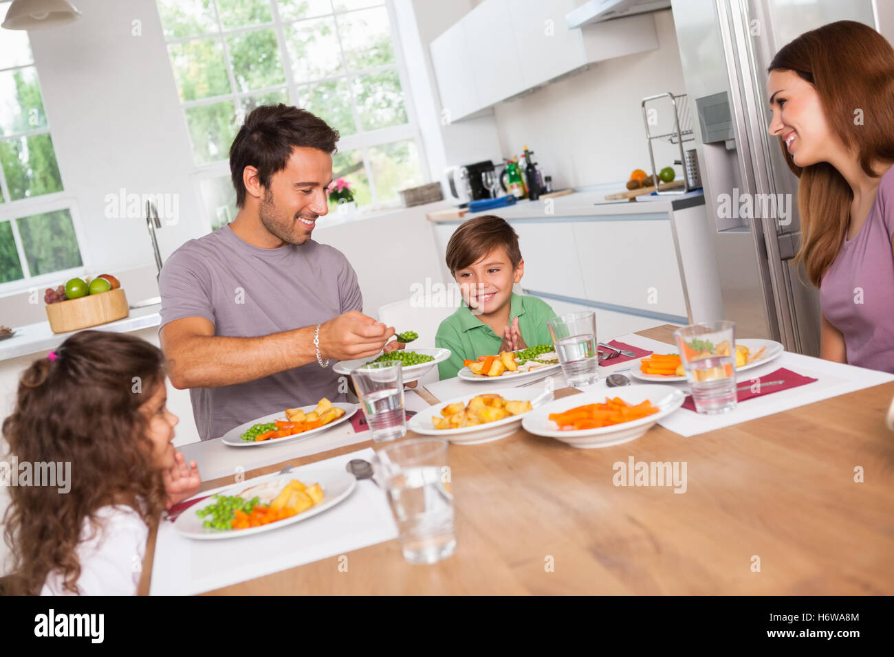 Padre di servire le verdure per figlio in cucina Foto Stock