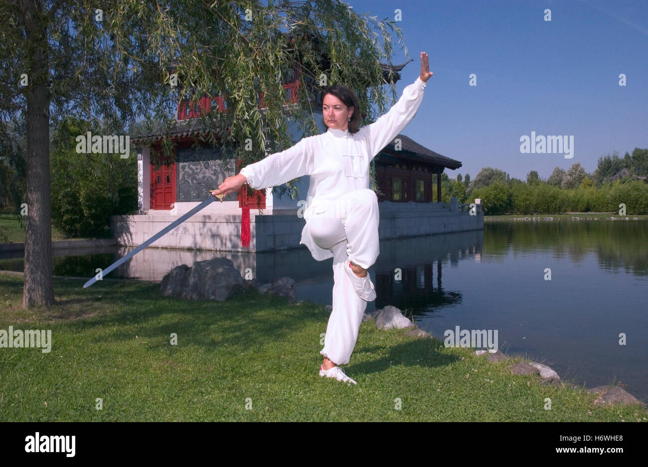Donna, inizio 40s, facendo Tai Chi con la spada in un giardino cinese a Berlino Foto Stock
