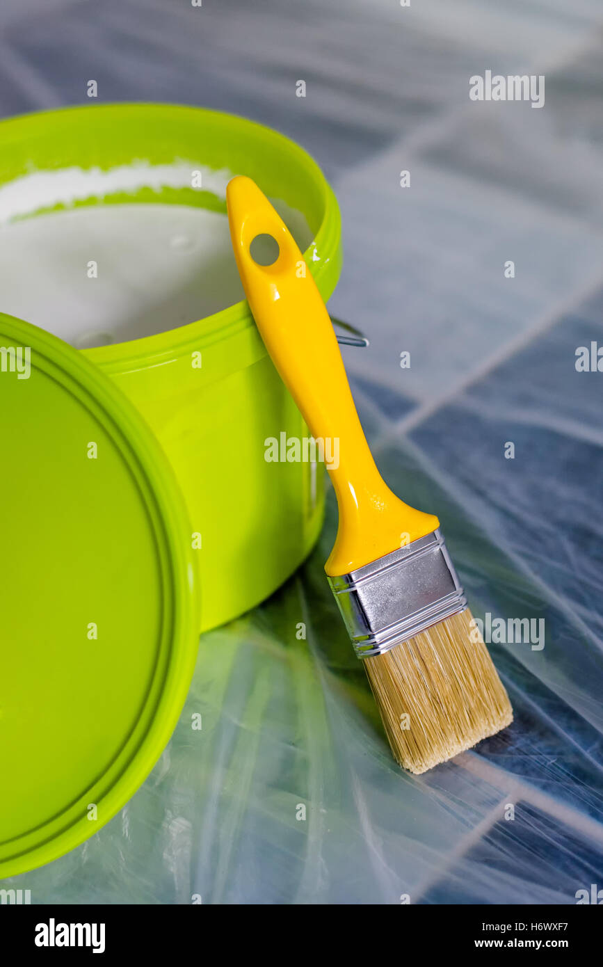 Vernice gialla spazzola e secchio verde sul pavimento, pronto per il lavoro domestico progetto e pareti redecoration Foto Stock