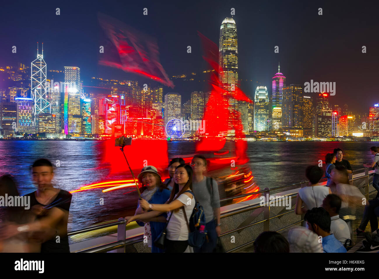 Il famoso quartiere Tsim Sha Tsui promenade e turisti che si godono la sera il panorama dell'Isola di Hong Kong, Hong Kong, Cina. Foto Stock